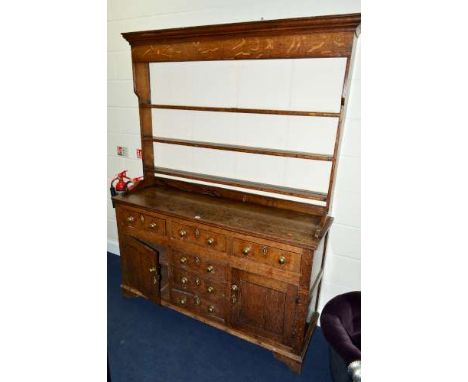 AN EARLY 19TH CENTURY OAK DRESSER, the upper section with a painted back board, three shelf boarded rack, the base fitted wit