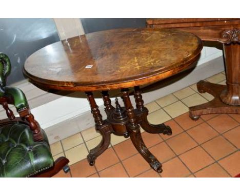 A VICTORIAN WALNUT AND INLAID OVAL CENTRE TABLE, on turned uprights and four octagonal splayed legs and ceramic casters