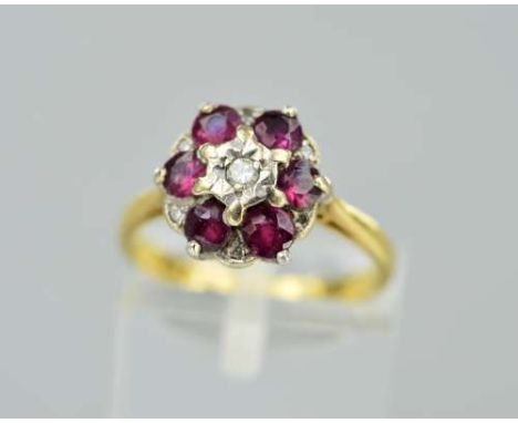 AN 18CT GOLD RUBY AND DIAMOND CLUSTER RING, the central modern round brilliant cut diamond within a ruby surround with single