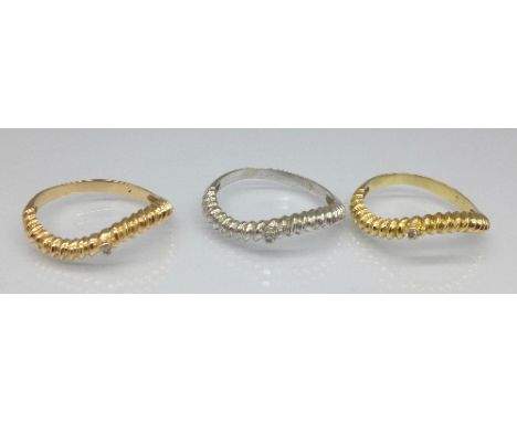 An 18ct gold interlocking trilogy ring, marked 750, each set with a small diamond, 6.1g, N