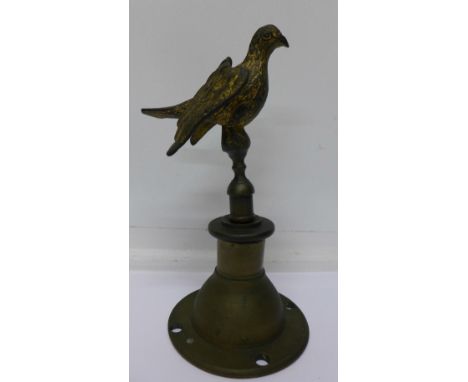 A brass finial in the form of a stylised pigeon