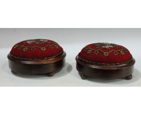 A pair of Victorian circular beadwork footstools, applied with flowers within a geometric border, red woollen ground, each re