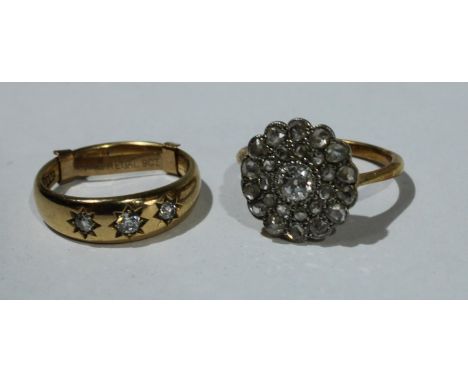 An 18ct gold and diamond cluster ring, 3.6g; an 18ct gold diamond three stone ring, 4.4g (2) 