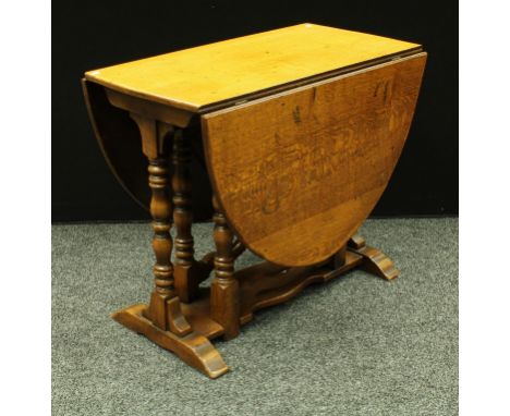 A 20th century oak gate leg table, oval top, turned legs. 