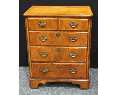 A walnut TV cabinet, quarter veneered rectangular top above a hinged front and a long drawer, bracket feet, brass handles, 84
