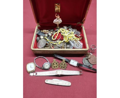 A musical jewellery box containing bracelet constructed with 1930s threepenny bits, a silver heart shaped locket, two militar