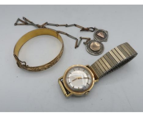 A gold cured hinged gate bracelet with bright cut decoration, two silver fobs, one on chain and a timex hand wound wristwatch