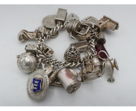 Sterling silver charm bracelet with ten shilling currency, Hull crest, ship, St Christopher, 1940 Quarter Dollar, church teap