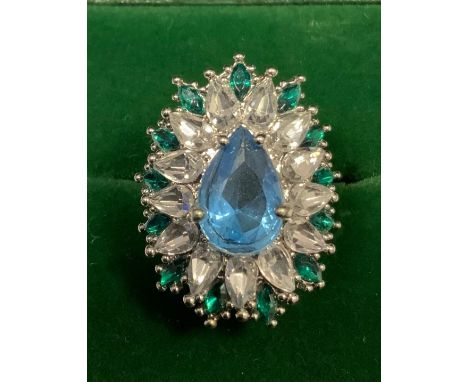 An Art Deco style shaped oval base metal dress ring, set with an arrangement of clear, green and blue glass stones, ring size