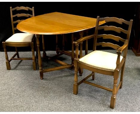 An Ercol style gate leg table, oval top; a conforming carver and dining chair (3) 