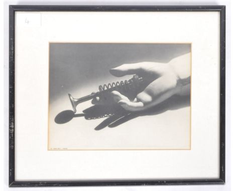 Man Ray (American, 1890 - 1976) -&nbsp; A&nbsp;vintage photogravure depicting a wooden hand holding a coiled piston. To the b