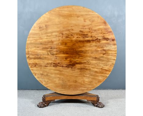 A George IV Figured Mahogany Circular Breakfast Table, on turned central column, triangular inswept base, on bold carved claw