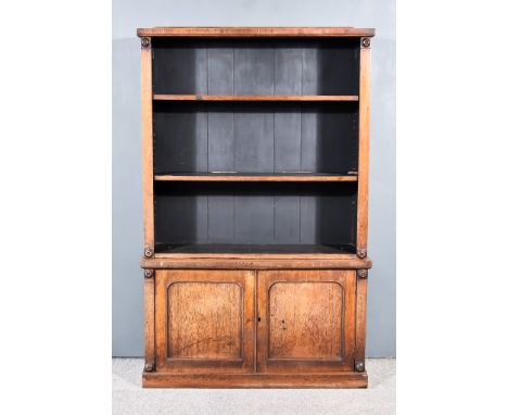 An Early Victorian Mahogany Bookcase, the upper part with shaped cresting, fitted two open shelves, the base fitted cupboard 