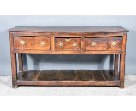 A Late 17th Century Panelled Oak Dresser Base, the three plank top with moulded edge, fitted three frieze drawers, on square 