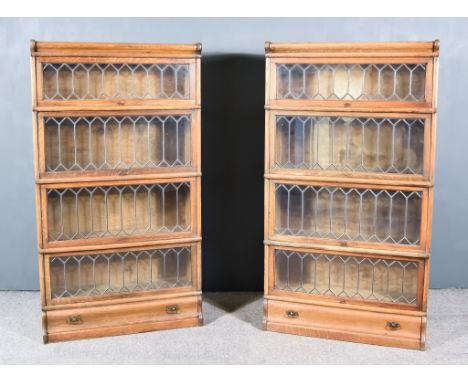A Pair of Late 19th/Early 20th Century Oak Four Tier Sectional Bookcases, each tier enclosed by a lead glazed rising front, w