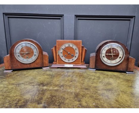A 1930s mahogany and inlaid mantel clock, 29cm diameter; together with two further oak examples. (3) 