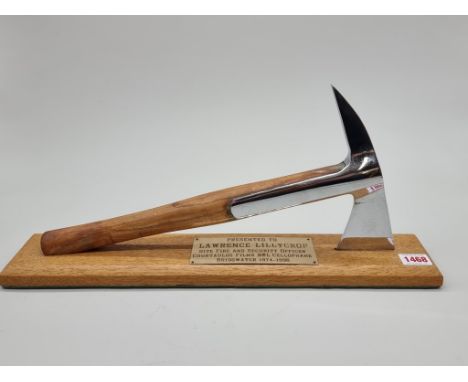 A presentation fire axe, on oak plinth, bearing inscribed plaque, 47.5cm long.&nbsp; 