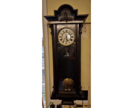 A late 19th century Vienna style ebonized wall clock,&nbsp;with enamel dial, 107cm high, with pendulum and weight. 