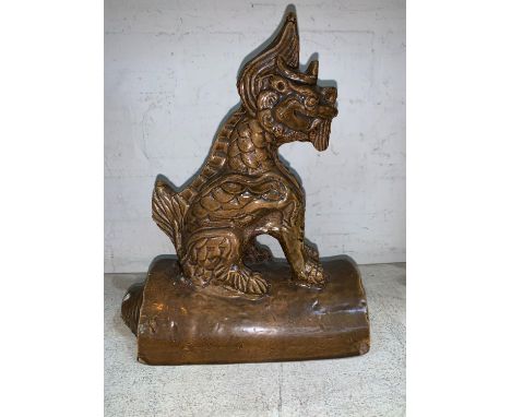 A Chinese terracotta roof tile with seated dragon on top 