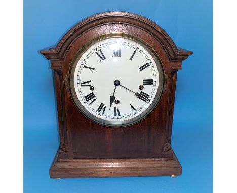 An early 20th century Georgian style mantel clock in mahogany arch top case, with white dial and chiming movement striking on