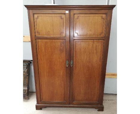 An early 20th century Georgian style part fitted mahogany double wardrobe enclose by twin panel doors, on bracket feet, the i