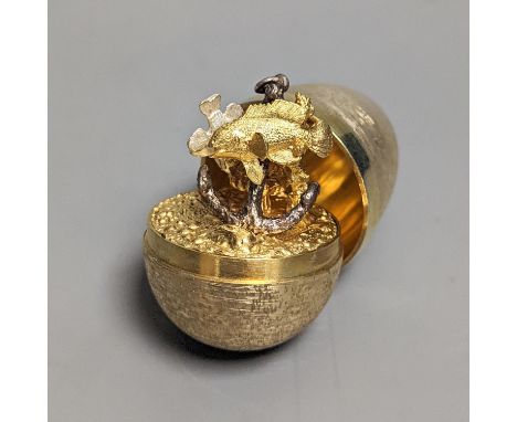 A 1970's textured silver gilt surprise egg by Stuart Devlin, opening to reveal a ship's anchor with fish, London, 1977, 71mm,