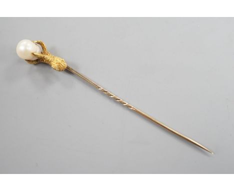 A 19th century yellow metal stick pin, the terminal modelled as an eagle's claw grasping a baroque pearl, 78mm, gross weight 