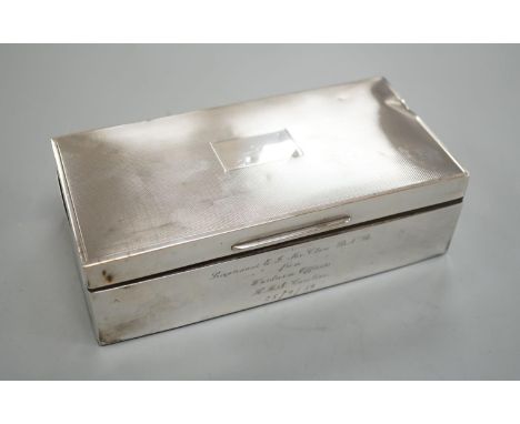 A late 1950's engine turned silver mounted rectangular cigarette box, with engraved inscription, 17.8cm.