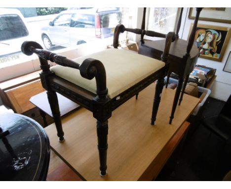 An carved mahogany piano stool
