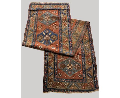 HERIZ RUNNER North West Iran, circa 1900, the terracotta field with a column of hexagons enclosed by serrated leaf and rosett