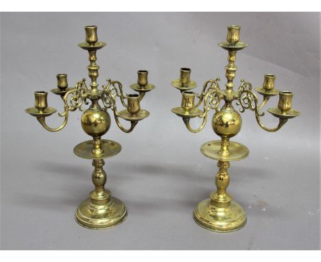 PAIR OF DUTCH STYLE BRASS FIVE LIGHT CANDELABRA with four scrolling arms on a ball and baluster column, height 45cm, width 33