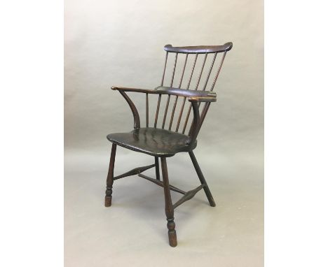 COMB BACK WINDSOR CHAIR mid 19th century, ash and elm, with a horse shoe arm rest with scrolled terminals, solid seat and tur