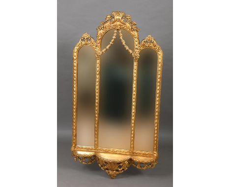 GILTWOOD TRIPLE MIRROR the arched plates beneath a foliate crest and above a shelf, height 150cm, width 80cm