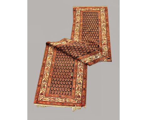 NORTH WEST PERSIAN RUNNER circa 1920, the midnight blue field of stylised boteh enclosed by ivory borders of serrated angular