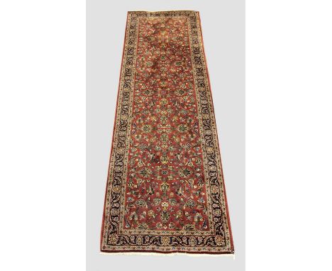 KASHAN RUNNER Central Iran, circa 1970, the raspberry field of scrolling vines and palmettes enclosed by indigo borders of me