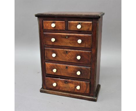 MAHOGANY MINIATURE OR COLLECTORS CHEST OF DRAWERS mid 19th century, the two short and four long drawers with ceramic pulls, h