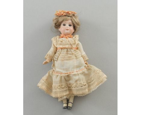   Kleine Puppe von Theodor Recknagel.   Halsmarke R 15/o A. Biskuitkopf. Massekörper. Originale Kleidung. Um 1900. H 21 cm   