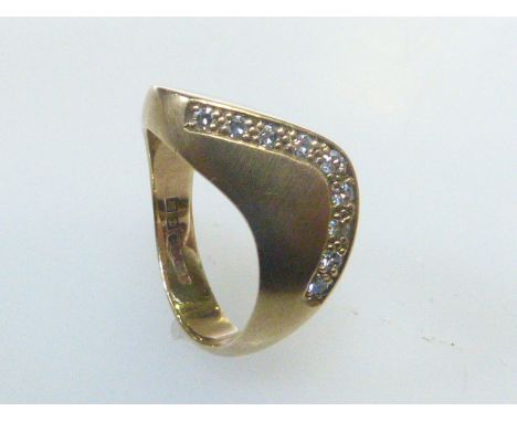 9ct gold and diamond ring of wave design, the nine uniform diamonds channel set, size M, hallmarked