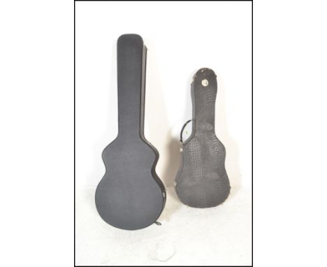 Two black faux leather guitar cases one having red velvet interior and lock catches, together with another made by Stagg havi
