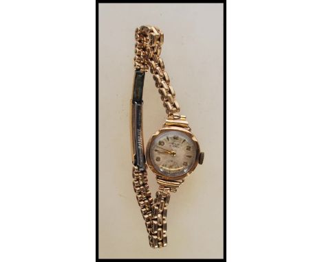 A vintage hallmarked 9ct gold ladies cocktail wrist watch by Avia, having an round white/ silvered dial and applied baton num