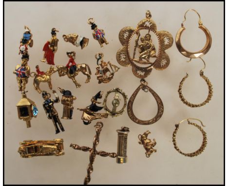 A small collection of yellow metal charms to include a policemen, post box, John Bull having a small dog with in, ship, witch