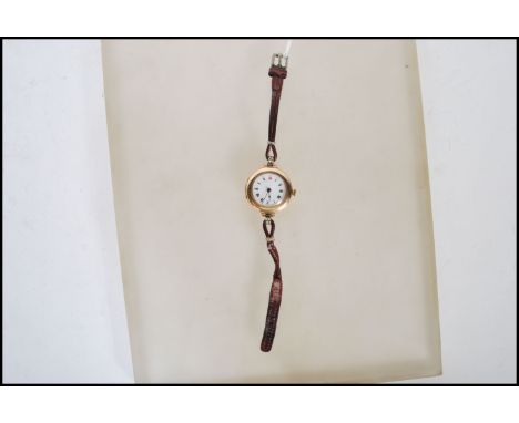 A early 20th Century hallmarked 9ct gold ladies wrist watch&nbsp;having a white enamel face with gilt surround with roman num