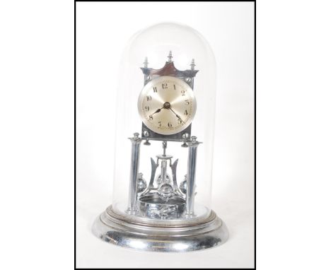 A 20th century Continental chrome anniversary clock, the silvered dial with Arabic numerals denoting hours, under a glass dom
