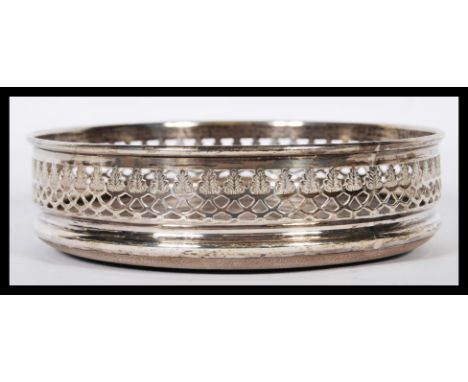 A silver Victorian hallmarked wine bottle coaster having a pierced gallery surround. London hallmarked for 1973. Measures 14c