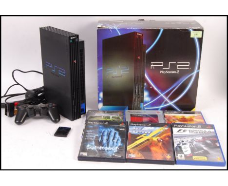 A boxed PS2 Play Station video games computer console with A/C adaptor, scart cable, control pad and a collection of 6x games