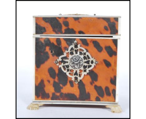 A 19th Century square blond tortoiseshell tea caddy, having ivory diamond lattice panel decoration sitting on hairy paw feet 