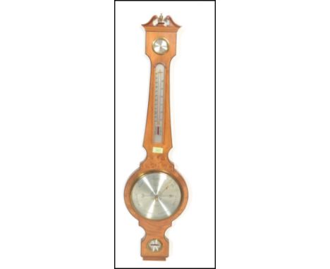 A 20th Century Georgian antique revival satin wood wooden cased wall barometer by Comitti of London having a round dial to th