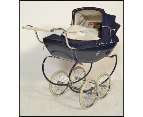 A vintage retro 20th Century Silver Cross childrens dolls pram finished in blue. The hooded pram raised on a chrome base and 