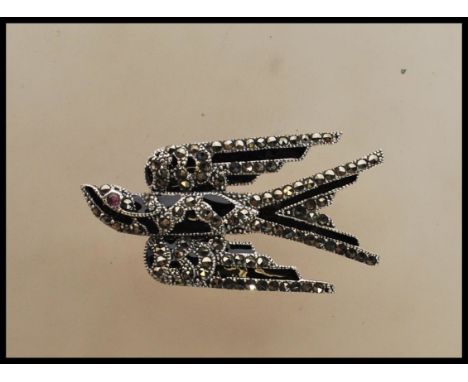 A wonderful silver marcasite and onyx adorned brooch in the form of a swallow bird. Art Deco style, the bird with amethyst se