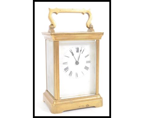 A 19th Century French gilt brass carriage clock having a white enamel face with Roman numeral chapter ring and faceted hands.